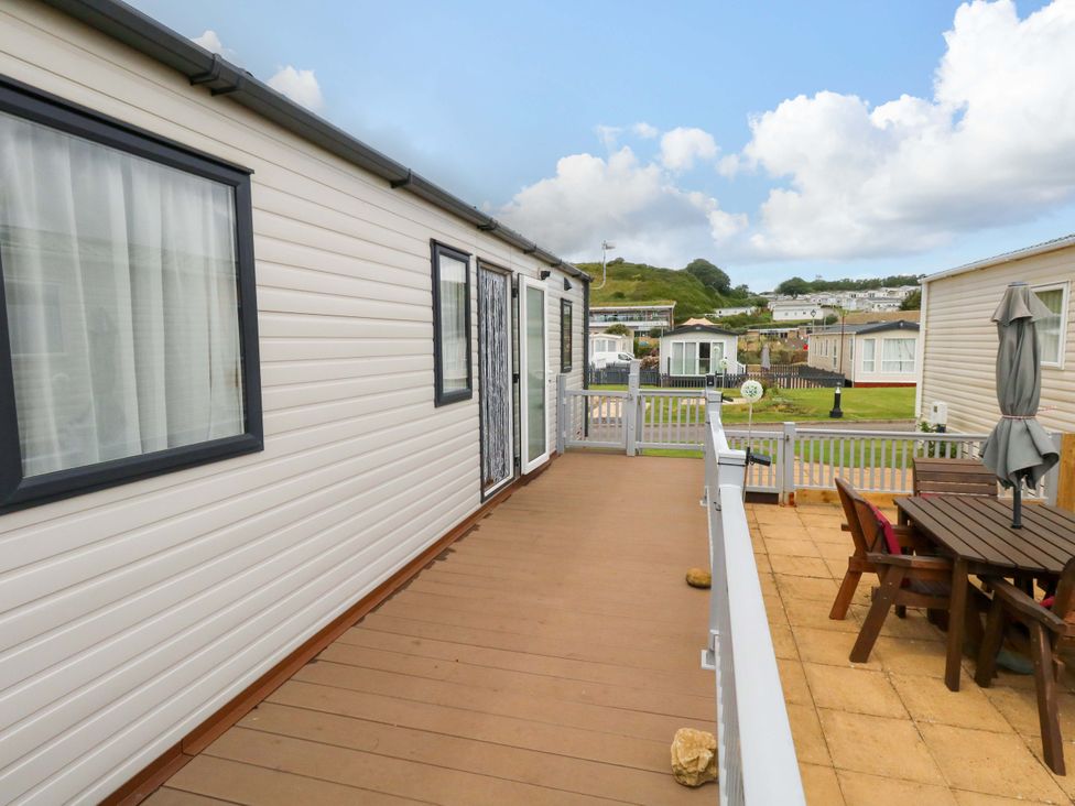 An outdoor deck with a table and chairs at Caravan A7 in Bridport