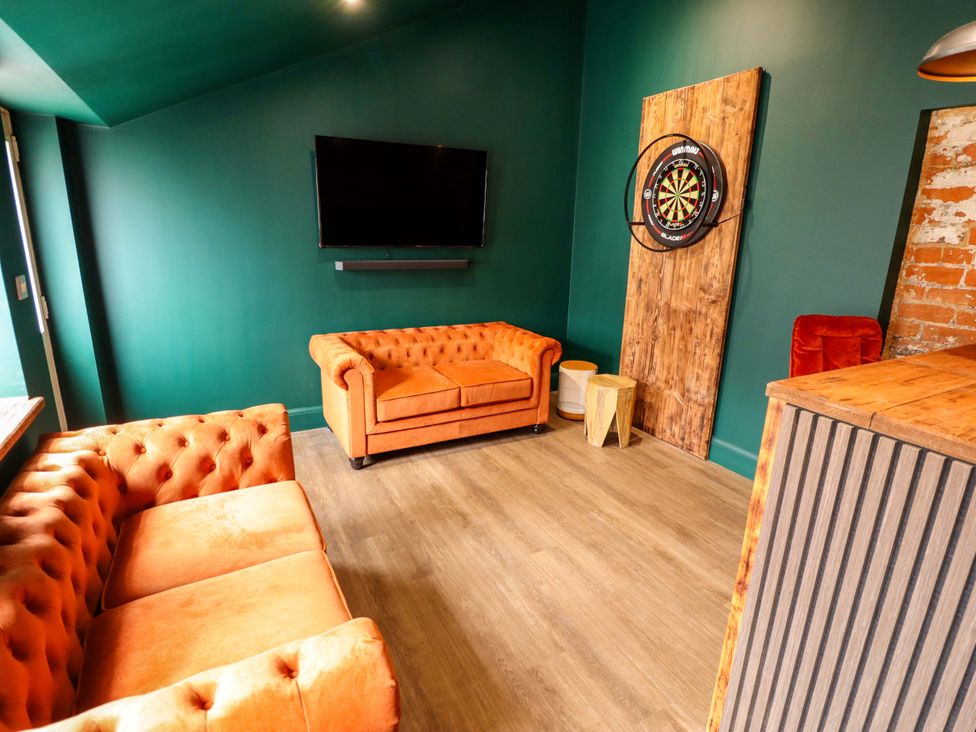A living room with a television and dartboard at 35 Wrawby Street in Brigg