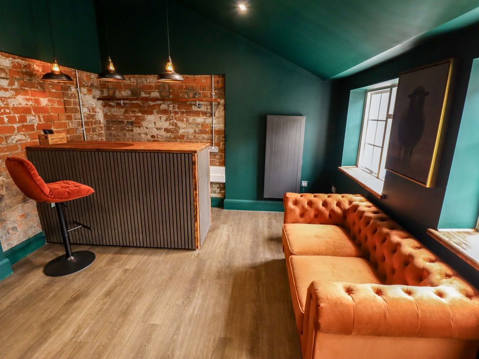 A living room with a bar counter and sofa at 35 Wrawby Street in Brigg