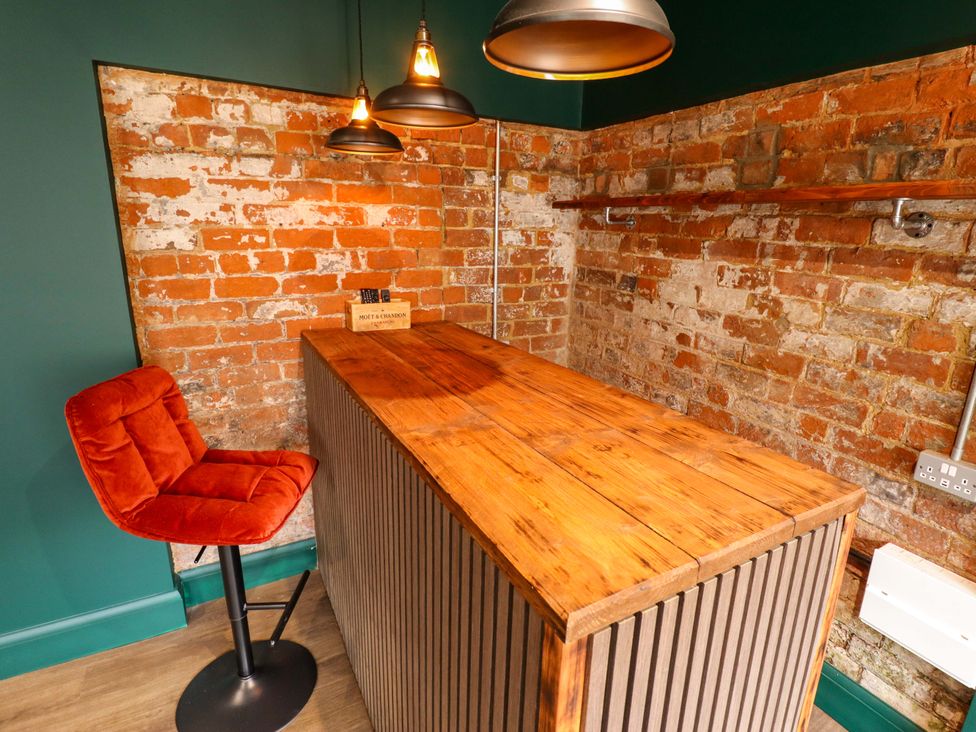 A home bar with a wooden counter and a bar stool at 35 Wrawby Street Brigg