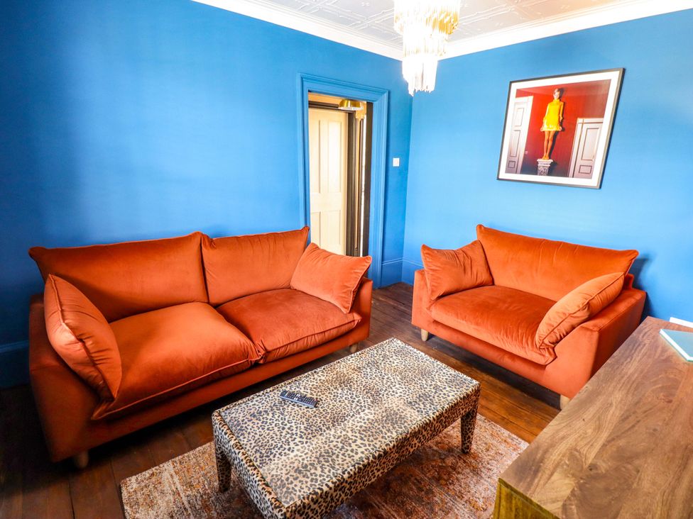 A living room with orange sofas and a coffee table at 35 Wrawby Street in Brigg