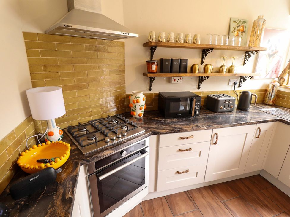 A kitchen with a gas stove and microwave at 35 Wrawby Street in Brigg