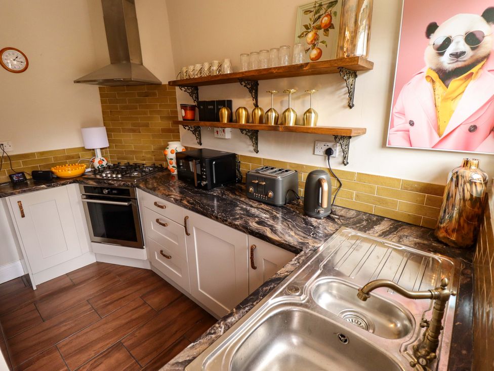 A kitchen with stove, sink, and shelves at 35 Wrawby Street, Brigg