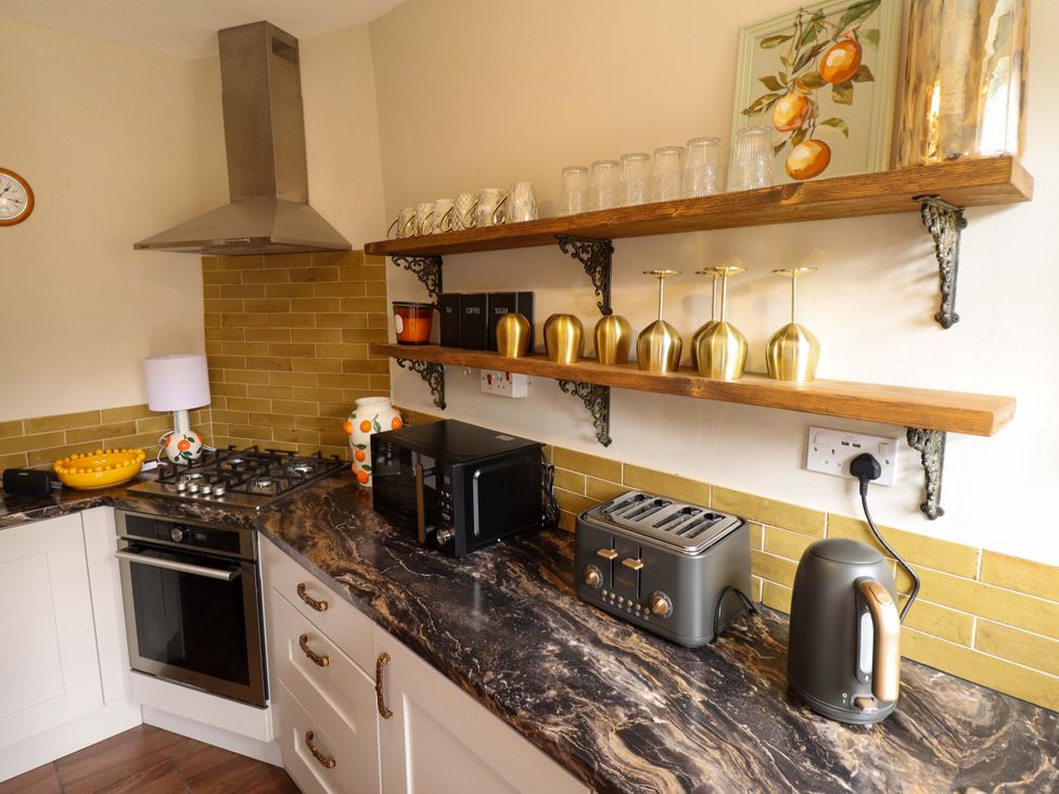 A kitchen with appliances and shelving at 35 Wrawby Street in Brigg