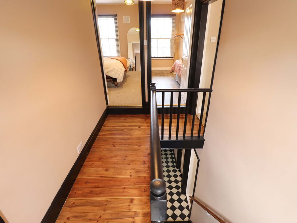 A hallway with a staircase and doors leading to bedrooms at 35 Wrawby Street in Brigg