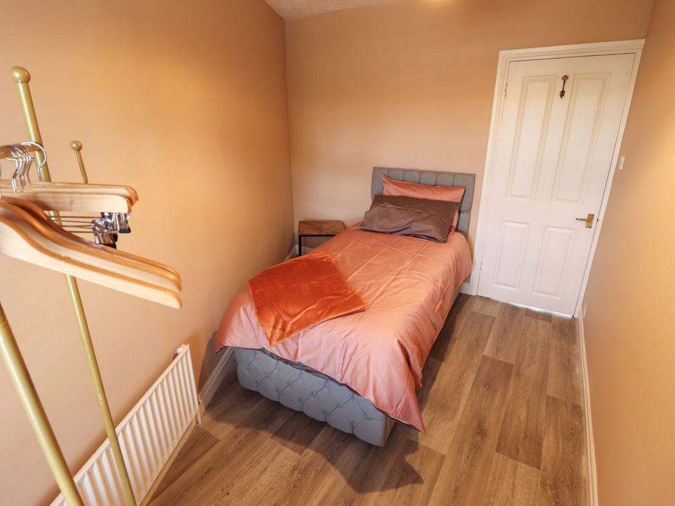 A bedroom with a single bed and a coat hanger at 35 Wrawby Street Brigg