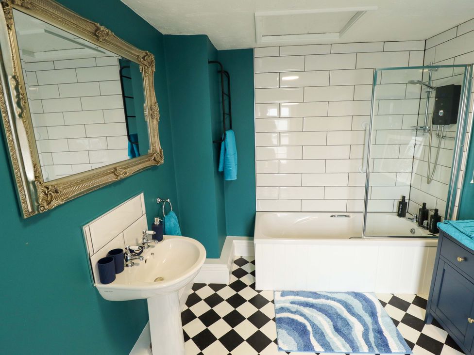 A bathroom with a sink, bathtub, and shower at 35 Wrawby Street in Brigg