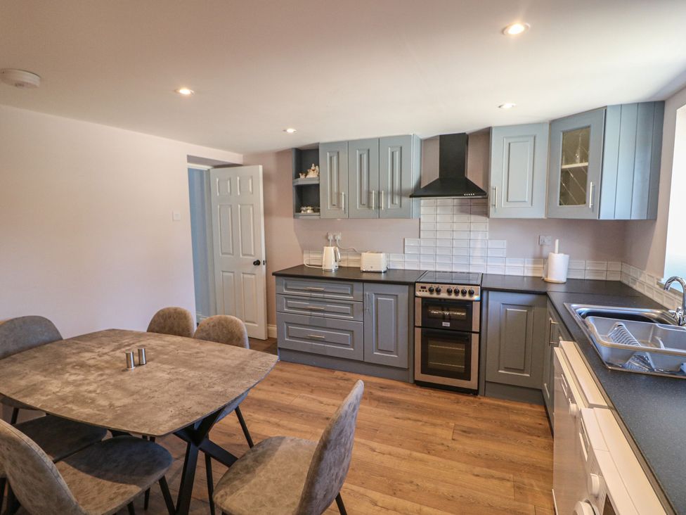 A kitchen with cabinets and a dining table at Abinas in Kenmare