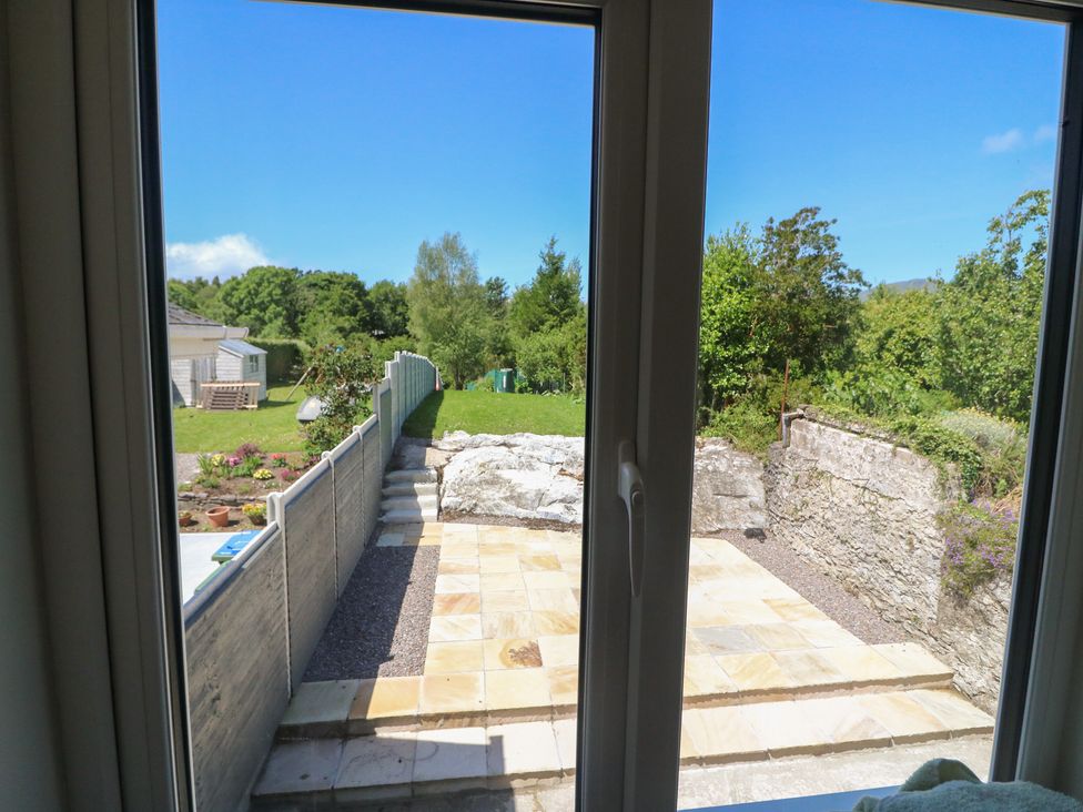 A garden view with a stone patio at Abinas in Kenmare