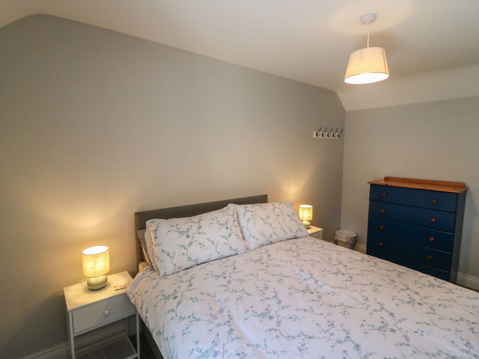 A bedroom with a bed and blue dresser at Abinas in Kenmare