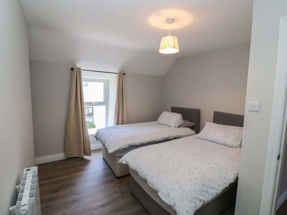 A bedroom with two beds and a window at Abinas in Kenmare