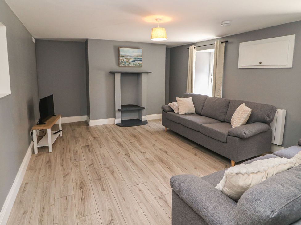 A living room with a television and a sofa at Abina's Kenmare, County Kerry
