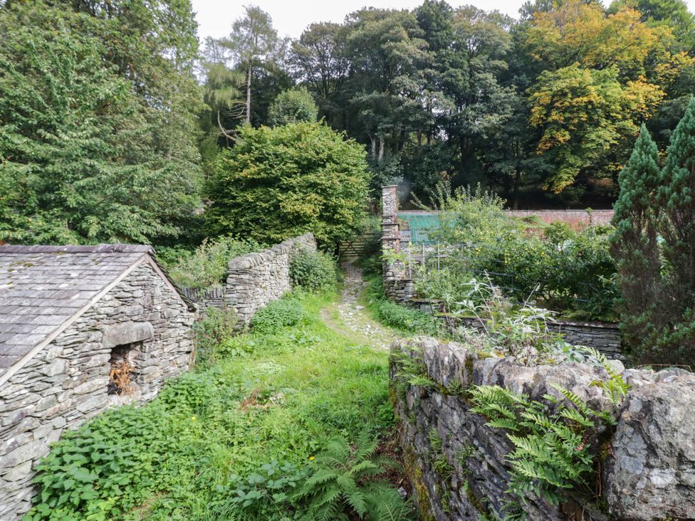An outdoor area with stone walls and a path in Flat 4 Grasmere Lodge Ambleside