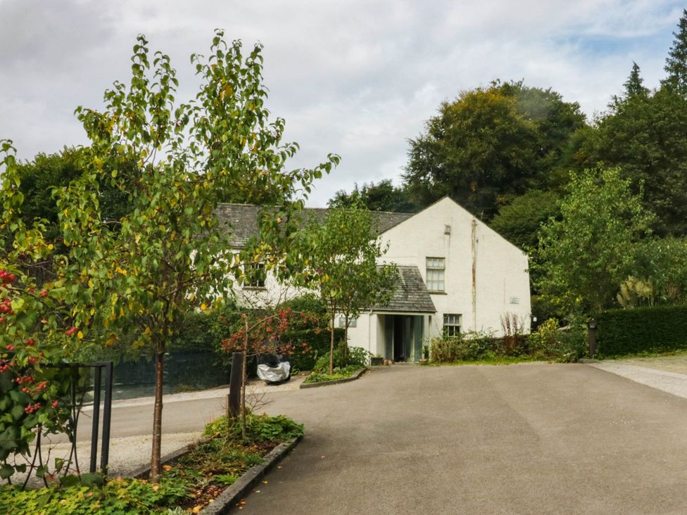 A house with a driveway and trees at Flat 4 Grasmere Lodge Ambleside