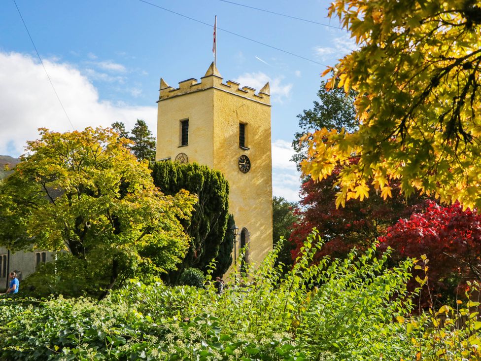 A yellow clock tower surrounded by trees at Dunmail Raise, Grasmere Lodge in Grasmere