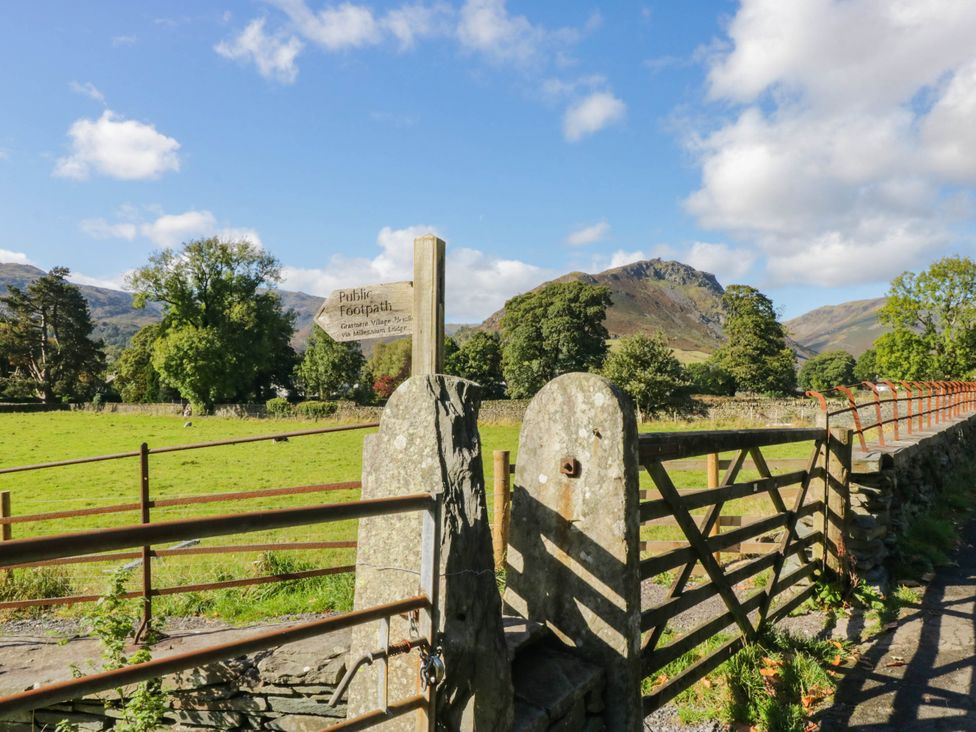 A gate with a public footpath sign and mountains in the background at Dunmail Raise, Grasmere Lodge, Grasmere