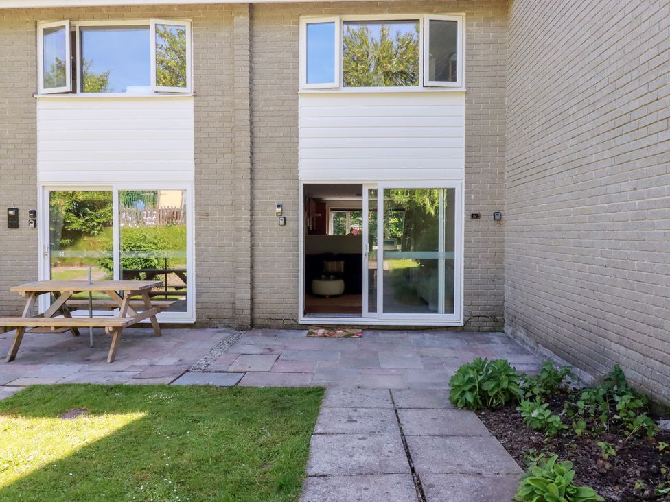 An outdoor patio area with a picnic table and entrance to a living room at 67 Manor Villas in Newquay