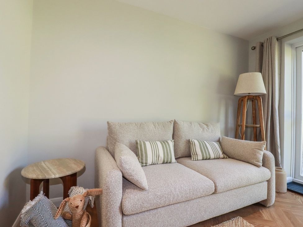 A living room with a sofa and a lamp at 67 Manor Villas in Newquay