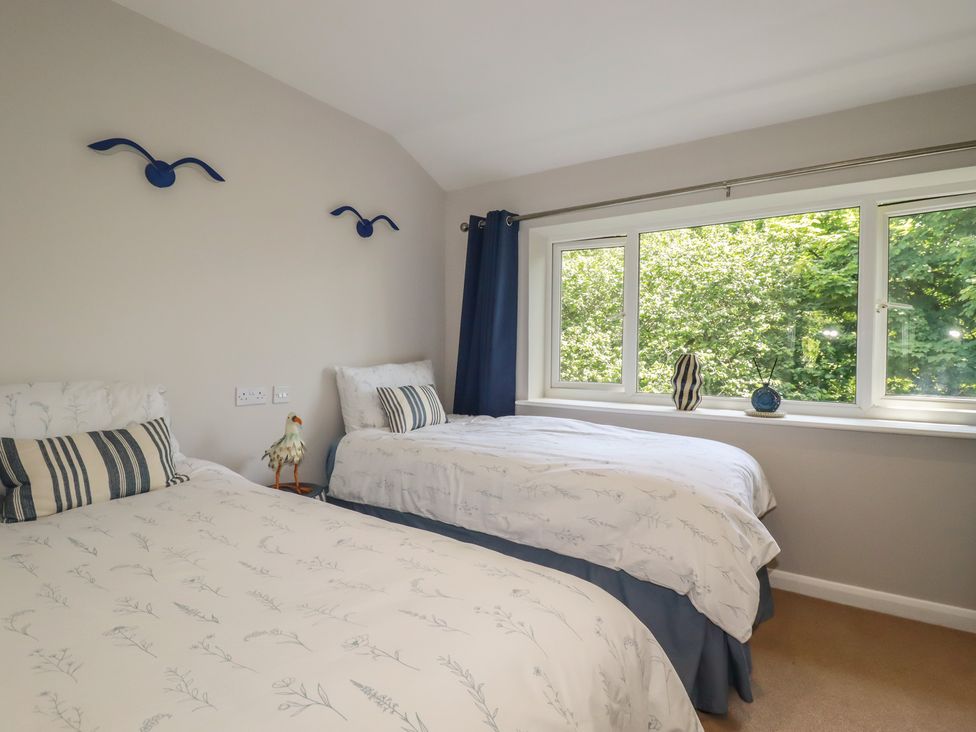 A bedroom with two beds and a window at 67 Manor Villas in Newquay