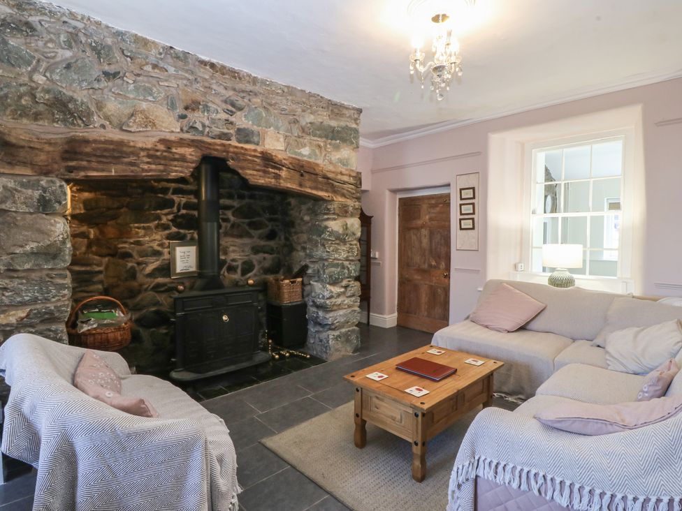 A living room featuring a fireplace and wooden furniture at Tan y Gader in Dolgellau