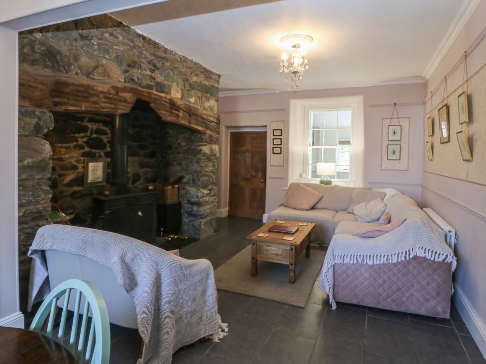 A living room with a fireplace and sofa at Tan y Gader in Dolgellau