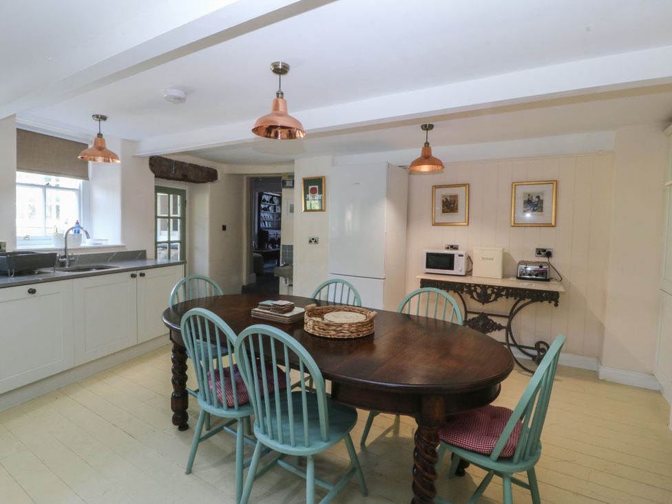 A kitchen with a table and chairs at Tan y Gader in Dolgellau