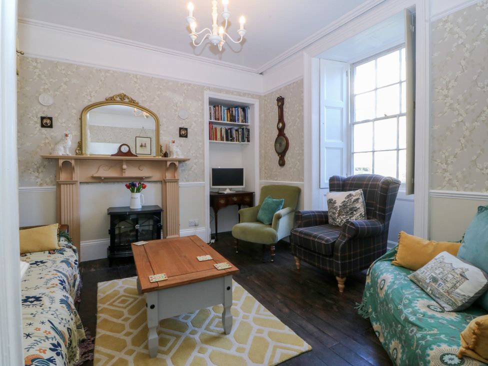 A living room with sofa and coffee table at Tan y Gader in Dolgellau