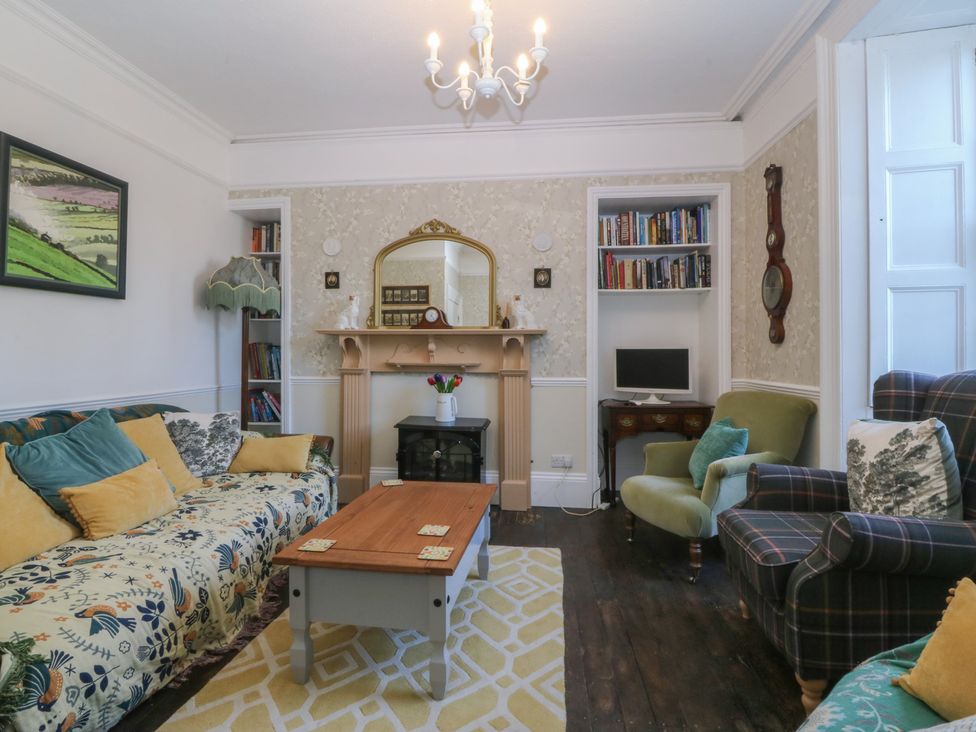 A living room with a sofa and coffee table at Tan y Gader in Dolgellau