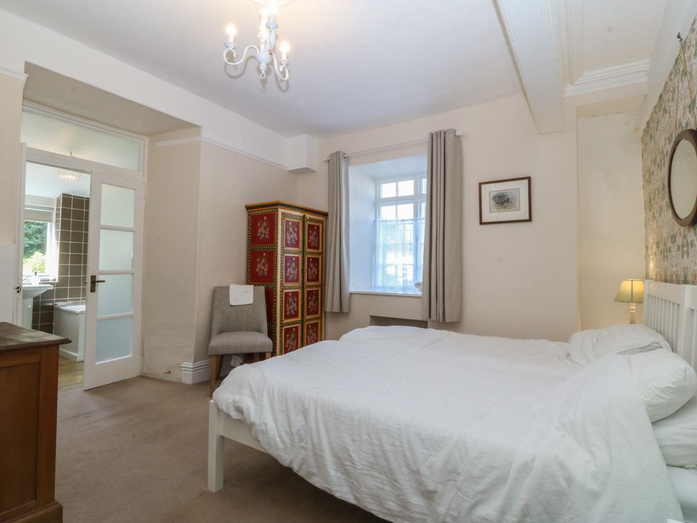 A bedroom with a bed and wardrobe at Tan y Gader in Dolgellau