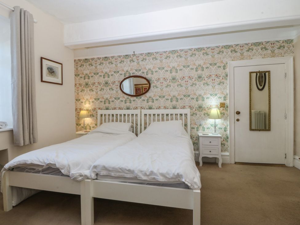 A bedroom with two beds and a lamp at Tan y Gader in Dolgellau