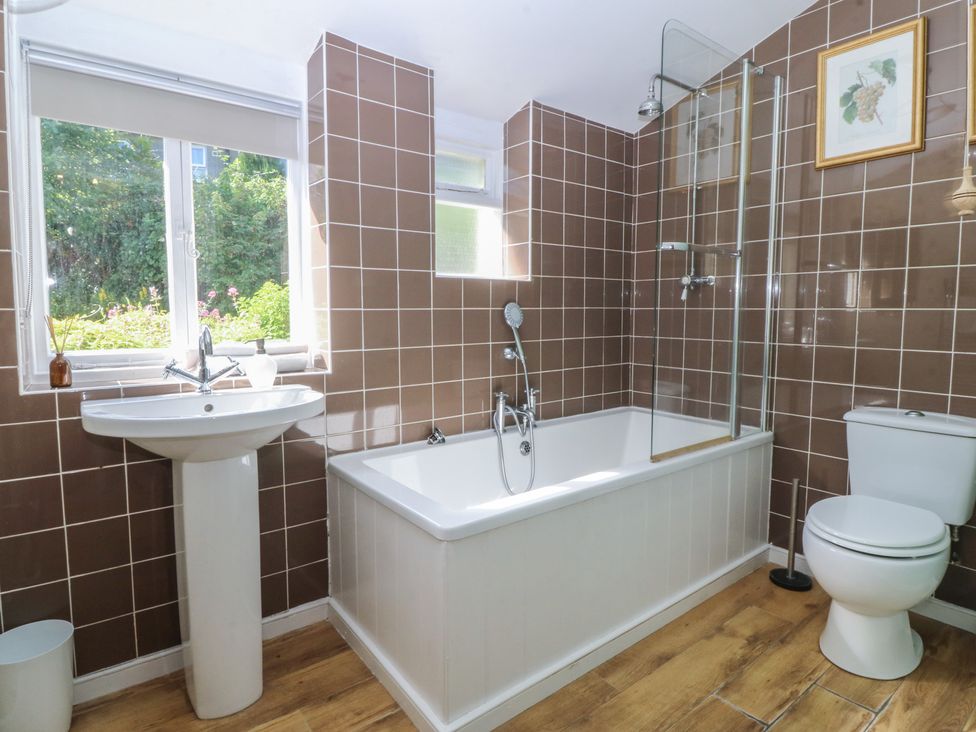 A bathroom with a bathtub, sink, and toilet at Tan y Gader in Dolgellau