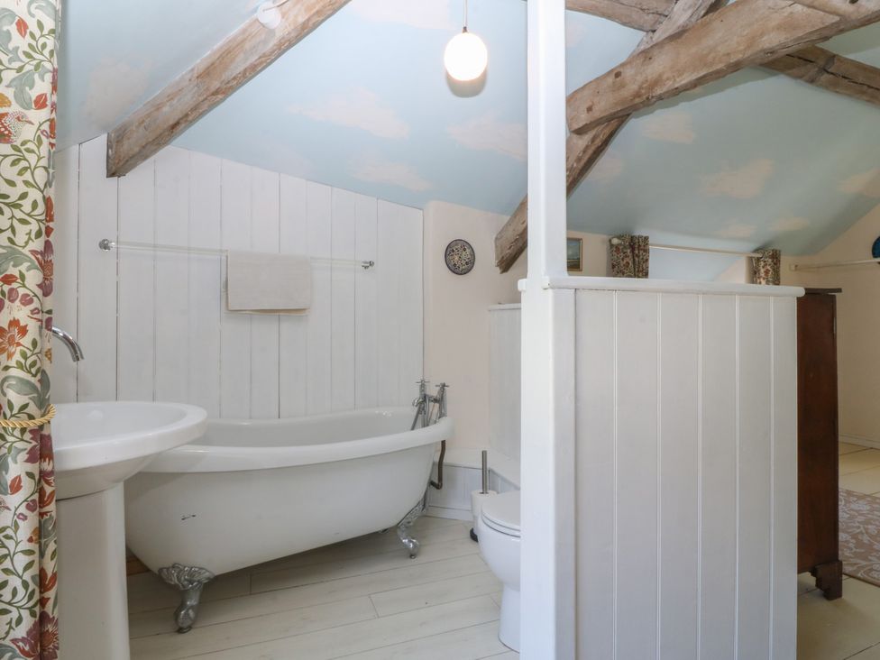 A bathroom with a bathtub, toilet, and sink at Tan y Gader in Dolgellau