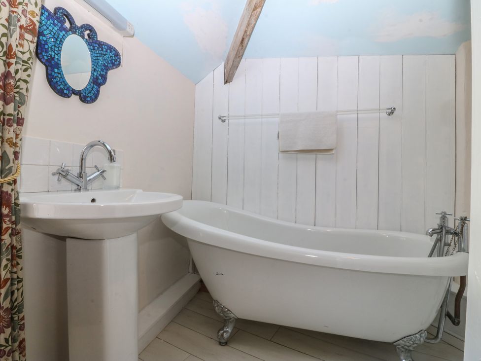 A bathroom with a bathtub and sink at Tan y Gader in Dolgellau
