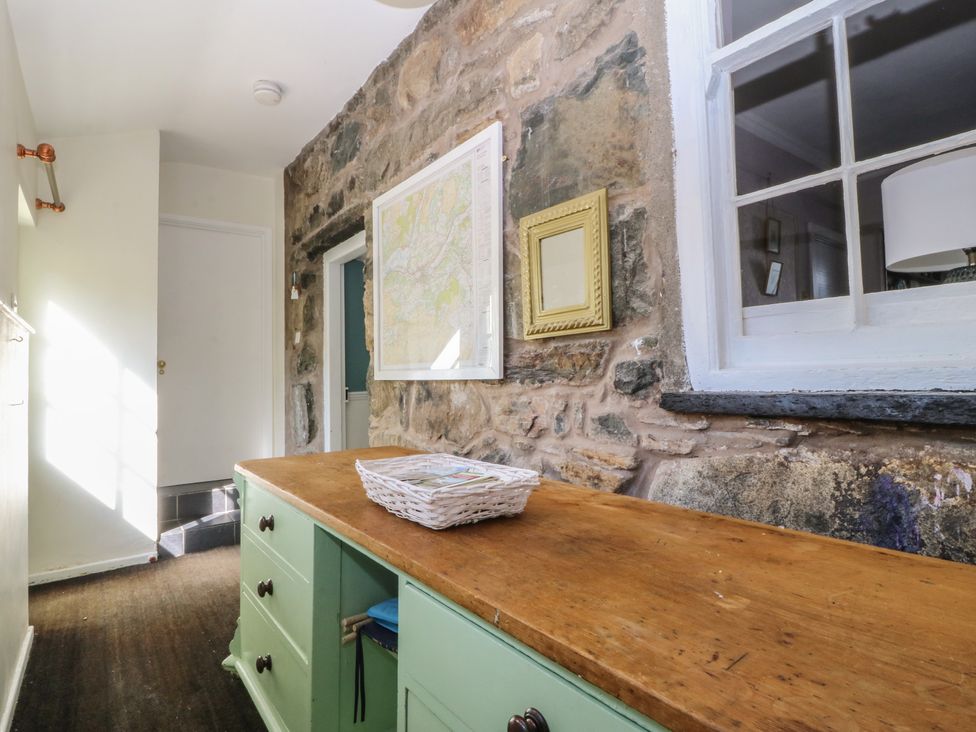 A hallway with a wooden table and a map at Tan y Gader in Dolgellau