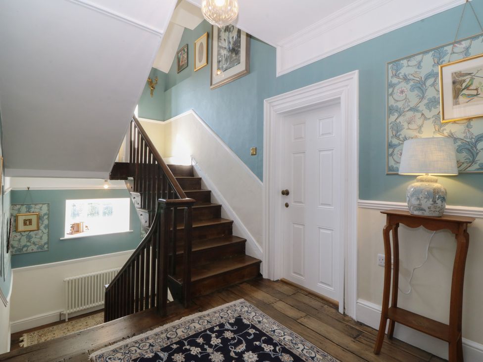 A hallway with stairs and decorative wall art at Tan y Gader in Dolgellau