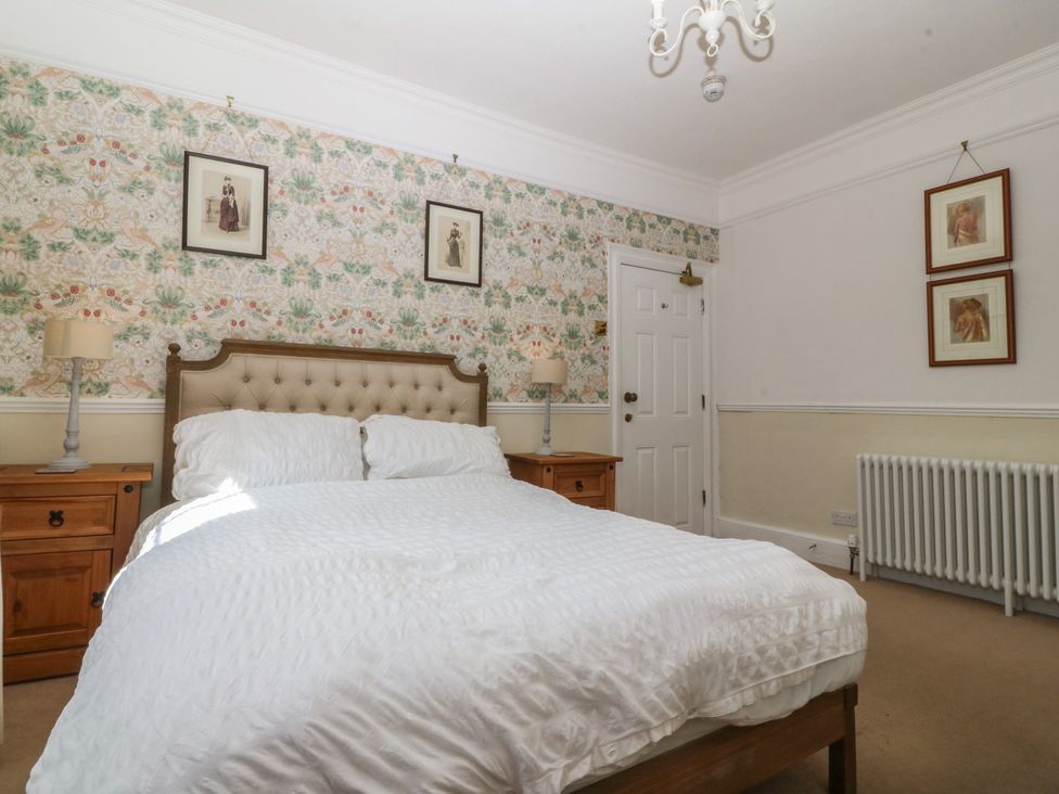 A bedroom with a bed and nightstands at Tan y Gader in Dolgellau