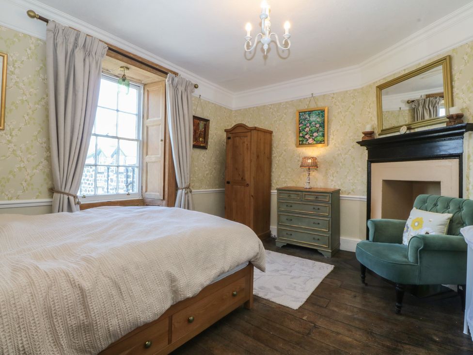 A bedroom with a bed and wardrobe at Tan y Gader in Dolgellau