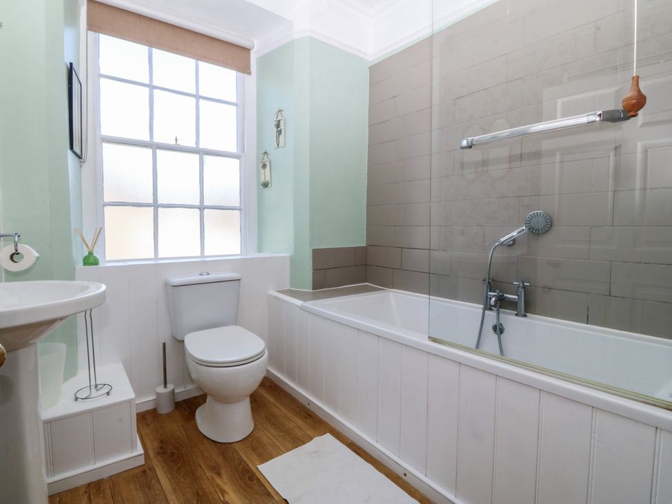 A bathroom with a bathtub, toilet, and sink at Tan y Gader in Dolgellau