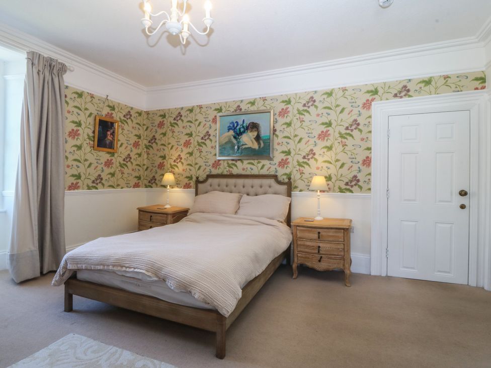 A bedroom with a bed and nightstands at Tan y Gader in Dolgellau