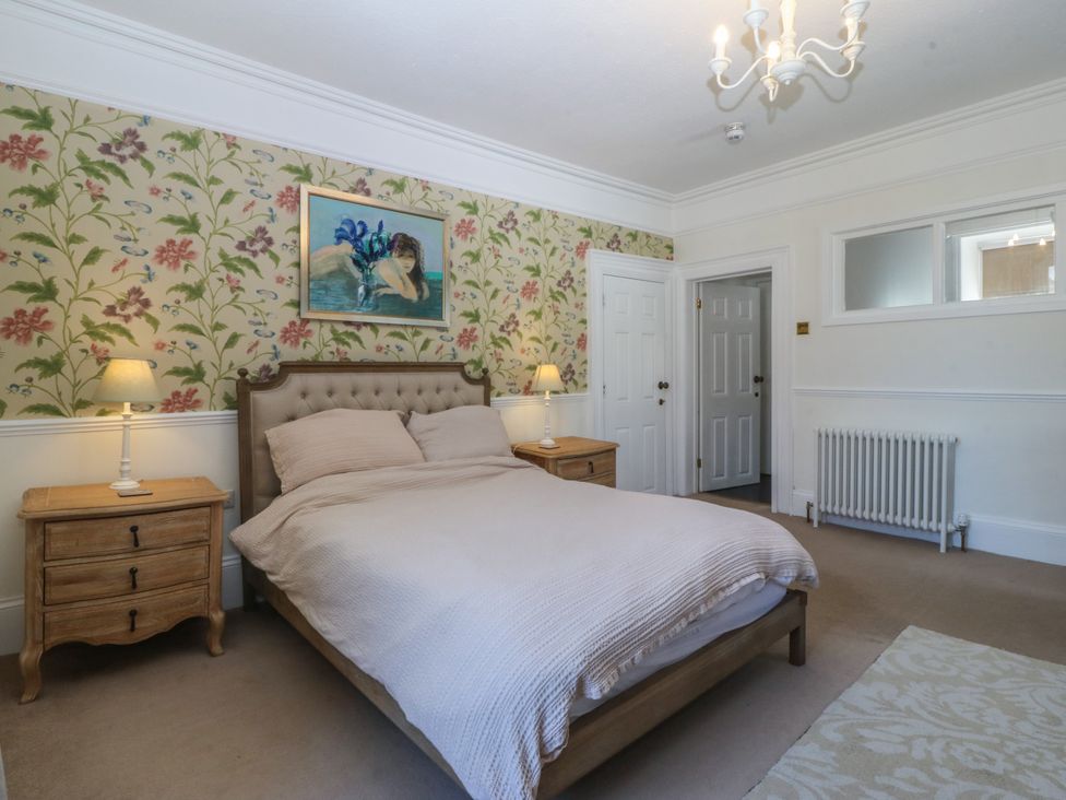 A bedroom with a bed and bedside tables at Tan y Gader in Dolgellau