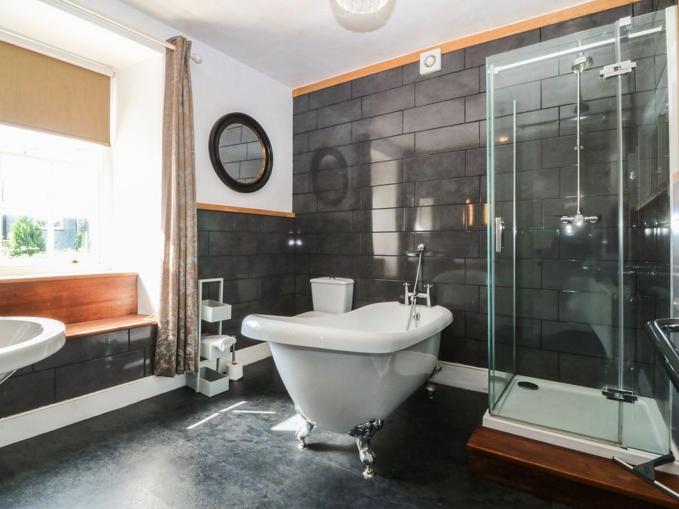 A bathroom with a bathtub, shower, sink, and toilet at Tan y Gader in Dolgellau