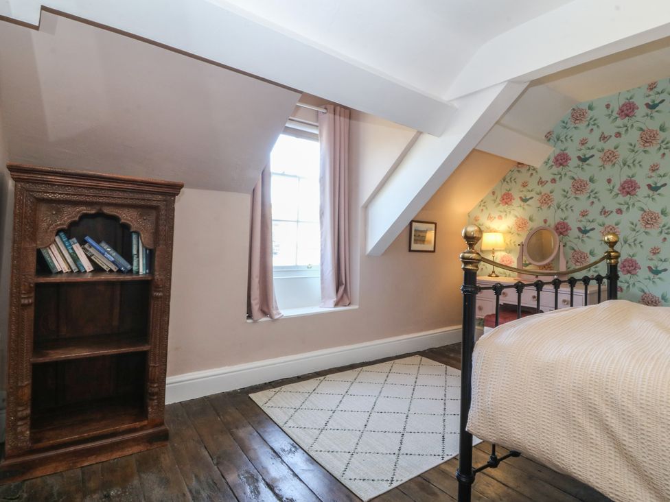 A bedroom with a bookshelf and a window at Tan y Gader in Dolgellau