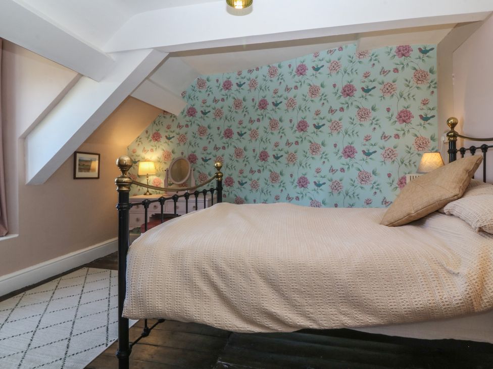 A bedroom with a bed and nightstand at Tan y Gader in Dolgellau