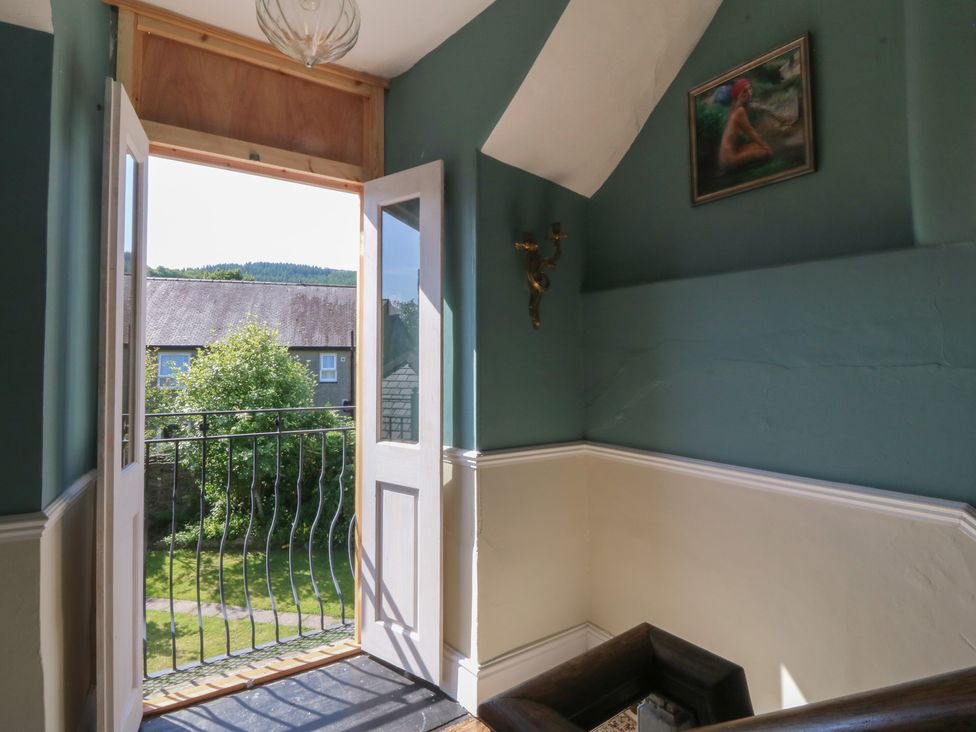 A staircase with an open door leading to a balcony at Tan y Gader in Dolgellau