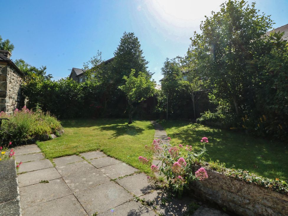 A garden with a pathway and flowers at Tan y Gader in Dolgellau