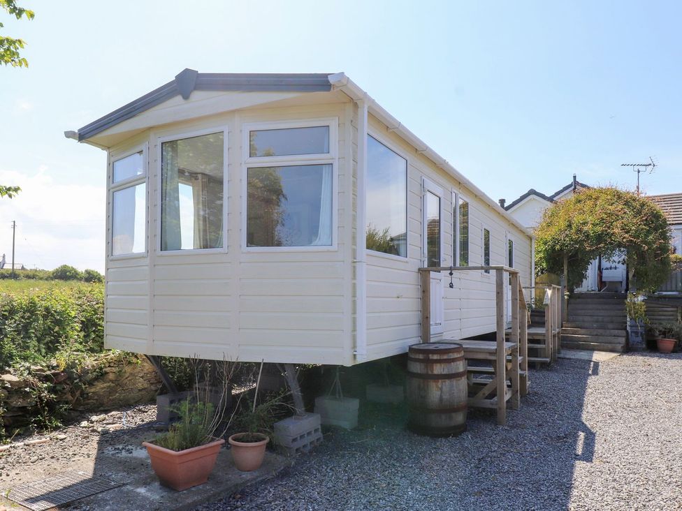 A mobile home with stairs and potted plants at The Lodge in Amlwch