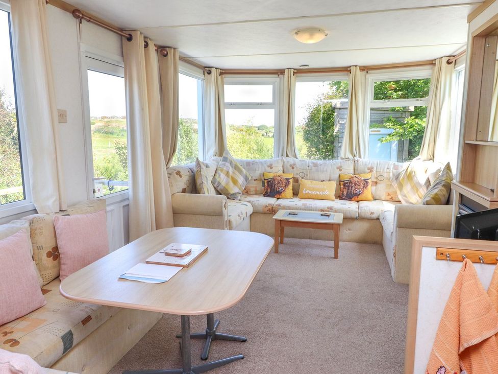 A snug with a sofa and coffee table at The Lodge in Amlwch
