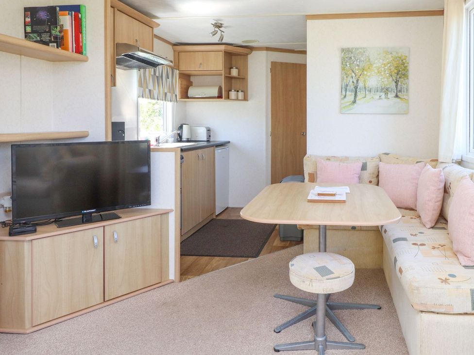 A living room with a sofa and television at The Lodge in Amlwch