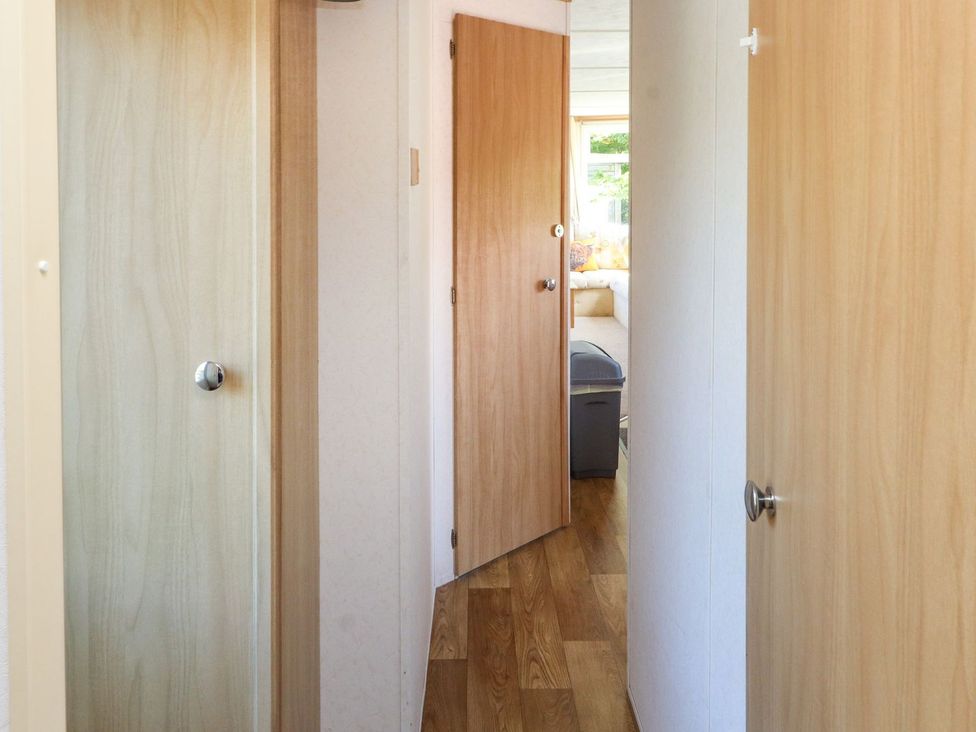 A hallway with doors leading to rooms at The Lodge in Amlwch