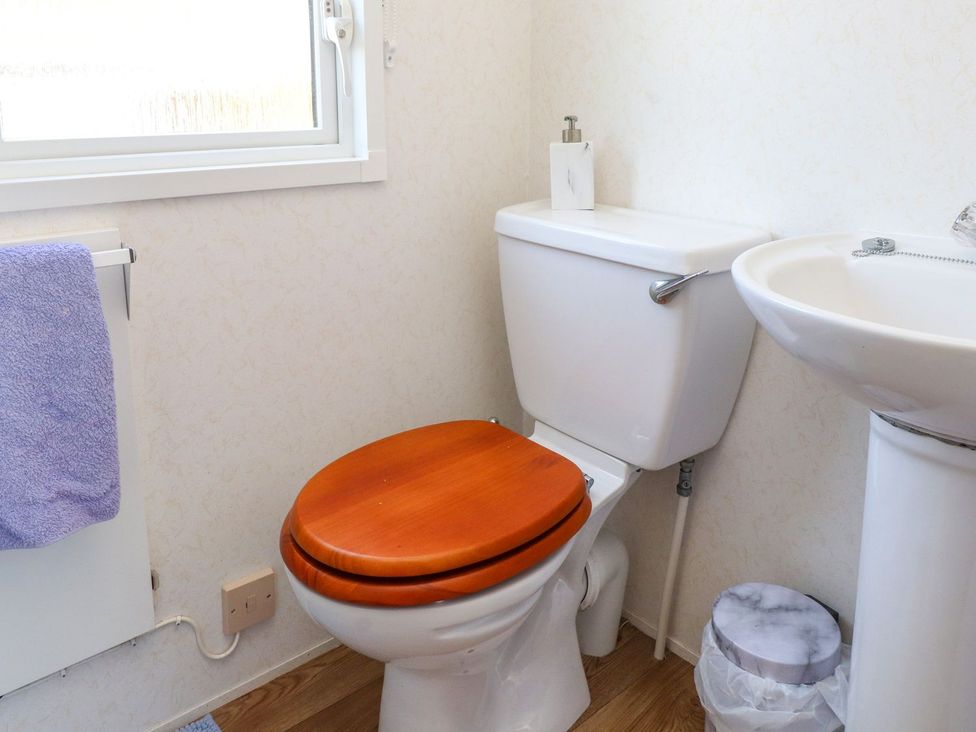 A bathroom with a toilet and sink at The Lodge in Amlwch